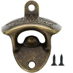 Destapador de pared para cerveza en metal tono bronce envejecido con la frase Fuck it, let's drink grabada, incluye dos tornillos de fijación negros.