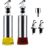 Dos dispensadores de aceite vidrio/acero inoxidable llenos (uno amarillo, otro oscuro), con vertedores, más embudo y dos vertedores repuesto.