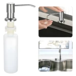 Dispensador de jabón empotrable cocina acero inoxidable cepillado, con botella blanca y acción de bombeo en uso.