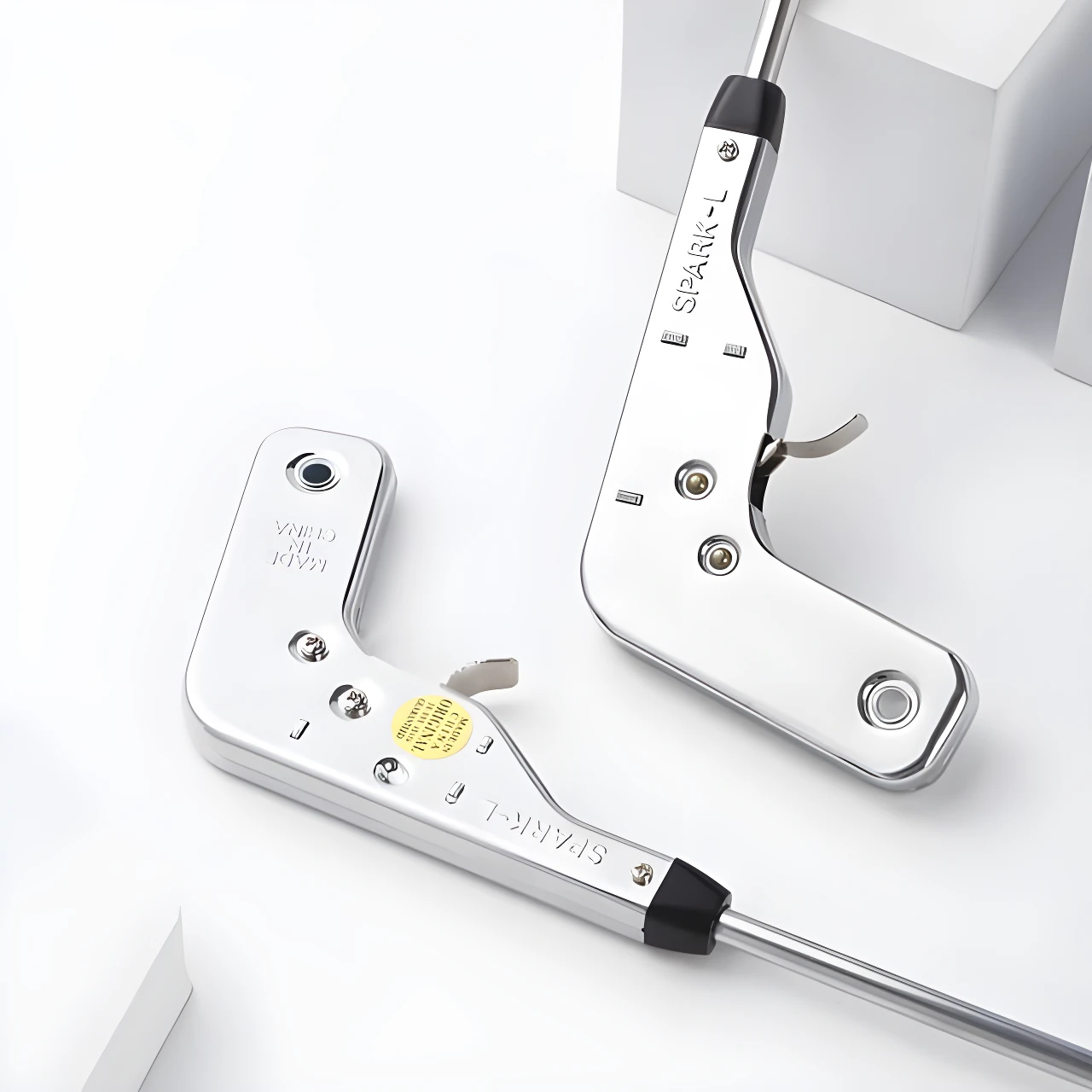 Dos encendedores de impacto largos con cuerpo metálico cromado brillante, modelo SPARK-L, sobre fondo blanco.