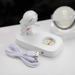 Lámpara astronauta de resina blanca con esfera de galaxia, cable USB incluido.