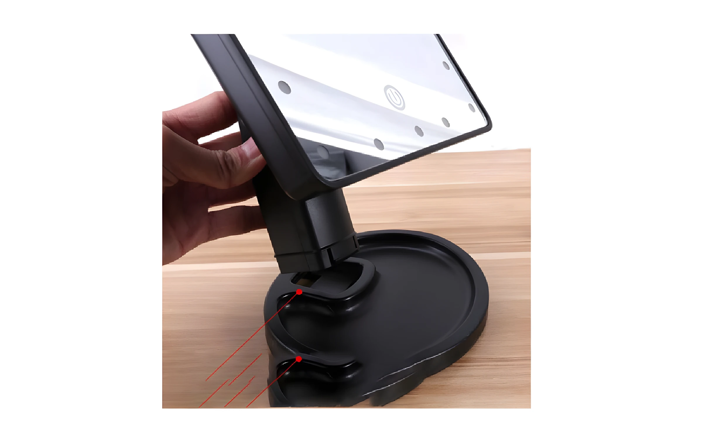 Espejo de maquillaje negro con base redonda y luces LED integradas, sujeto con mano.