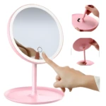 Espejo de tocador rosa con luz LED, pantalla táctil y base de apoyo, ideal para maquillaje.