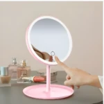 Espejo de tocador rosa con luz LED táctil, base redonda, ideal para maquillaje.