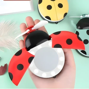 Espejo LED abanico ladybug rojo con alas abiertas, portátil y recargable USB para maquillaje.