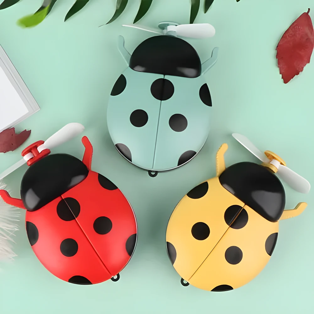 Tres mini ventiladores recargables con forma de mariquita roja, azul y amarilla, ideales para refrescar y aplicar maquillaje con luz.