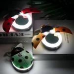 Espejo LED ladybug recargable, uno rojo, uno naranja y uno verde, con ventilador y luz circular.