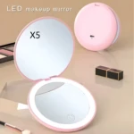 Espejo de maquillaje compacto rosa plegable con luz LED, amplificación X5, ideal para retoques.