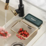 Estante esquinero plegable de malla fina dorada con tomates en fregadero.