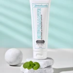 Exfoliante capilar 120 ml en tubo blanco con texto turquesa, sobre piedras y esfera de mármol, para limpieza profunda y recuperar vitalidad capilar.