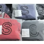 Forros elásticos para maleta talla S, empaques individuales en colores rojo, gris y lila, con etiquetas de producto y material 100% poliéster.