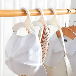 Set de 5 ganchos organizadores blancos en arco para colgar gorras, bolsos y bufandas en un armario.