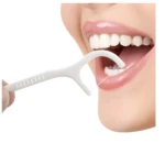 Palillo de hilo dental blanco en uso para limpiar dientes.