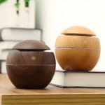 Humidificador difusor madera diseño bola, uno café y otro claro, con símbolo de encendido.