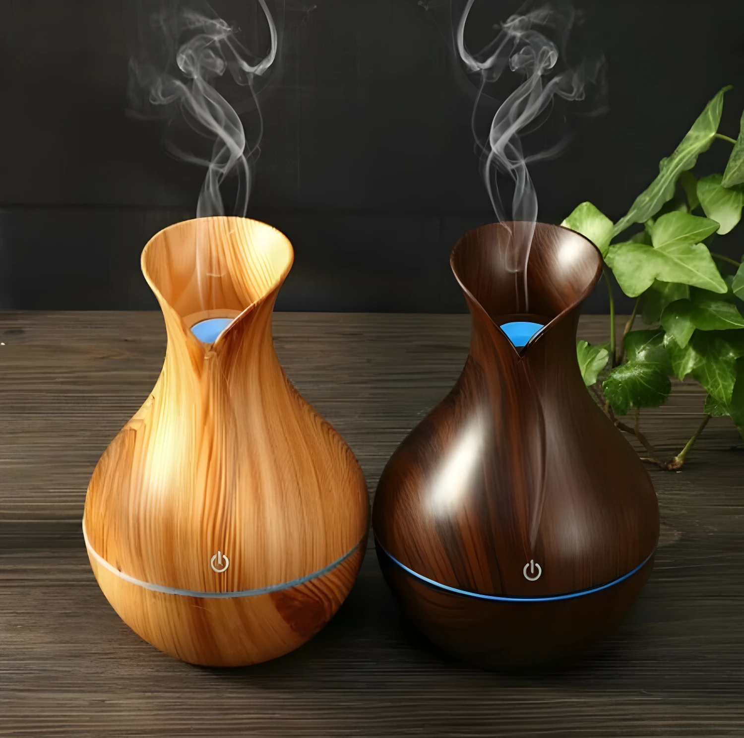 Humidificadores difusores USB diseño jarra, uno en madera clara, otro en madera oscura, liberando vapor en ambiente.
