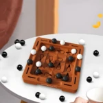 Juego de mesa de estrategia Orbitalchess de plástico marrón con esferas blancas y negras sobre mesa blanca.