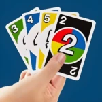 Mano sujetando cartas de UNO: 3 verde, 4 azul, 5 amarillo y 2 multicolor.