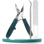 Set de pedicura con cortaúñas verde oscuro, limpiador de uñas curvo y lima en estuche, presentados sobre base turquesa.