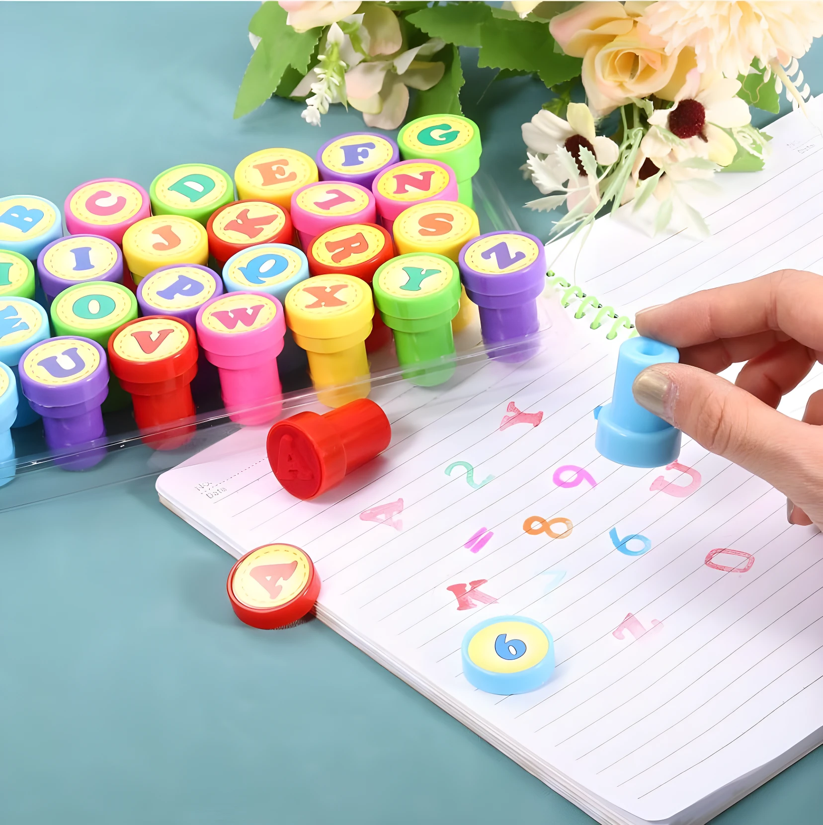 Set de sellos autoentintables de letras y números de colores vibrantes, siendo usados sobre cuaderno rayado.