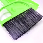 Cercano del cepillo de barrer de cerdas negras y del borde lima del recogedor plástico.