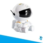 Proyector LED blanco figura astronauta sentado abrazando una nube sonriente, visor oscuro, detalles dorados, luz galaxia.
