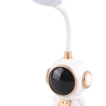 Lámpara de escritorio LED blanca con base de astronauta y detalles dorados, brazo flexible y visor negro brillante.