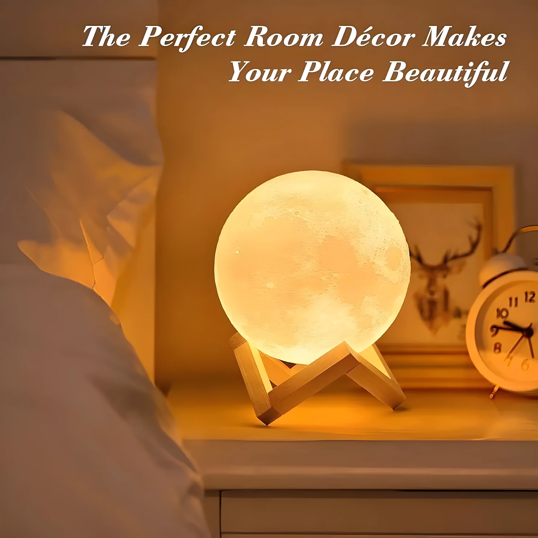 Lámpara de luna brillante sobre base de madera en mesa de noche con luz cálida, al lado de un despertador y un cuadro.