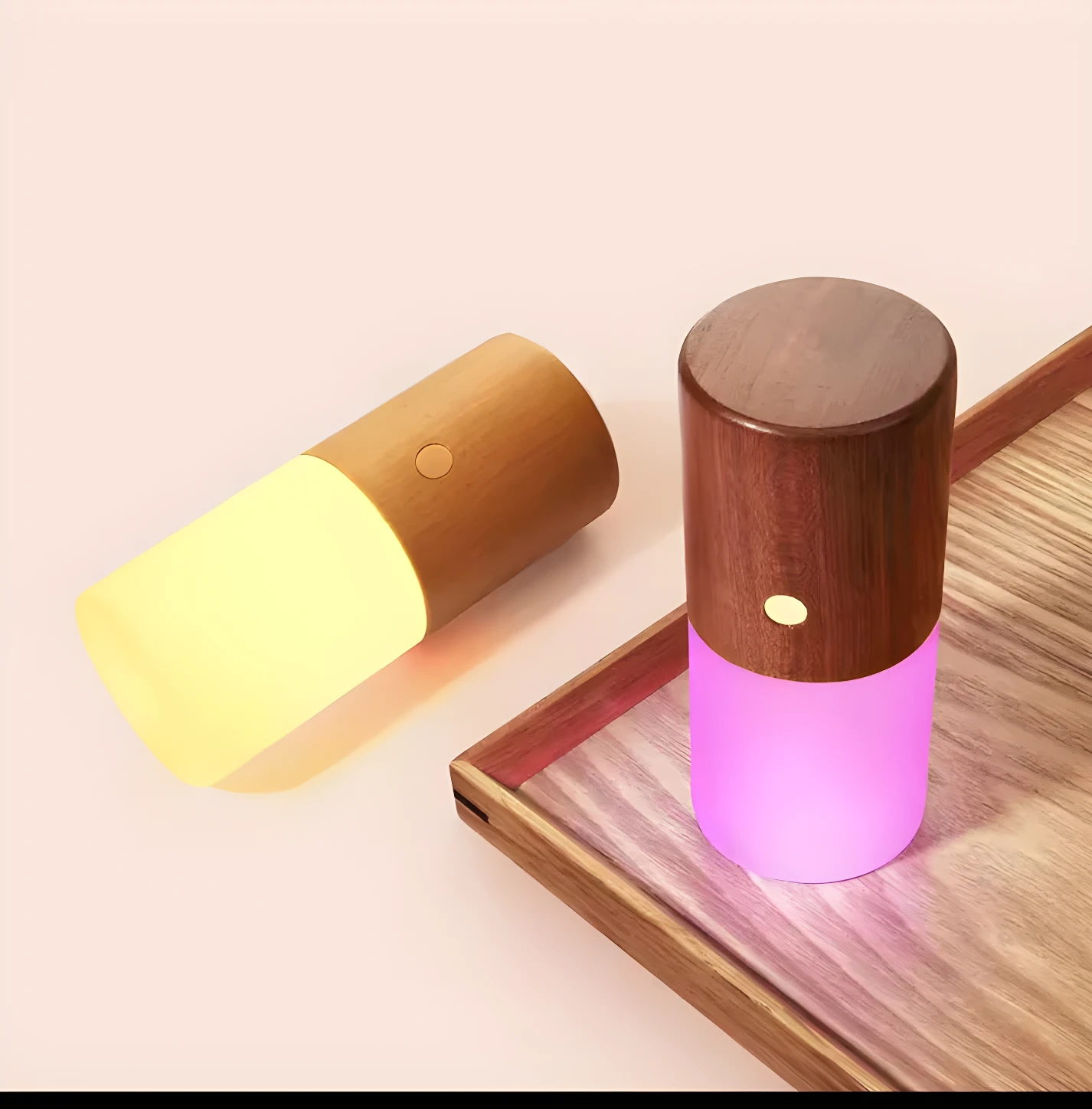 Lámpara de mesa cilíndrica con base de madera oscura y luz inferior magenta, junto a otra con luz amarilla tenue.
