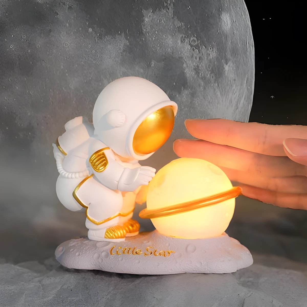 Lámpara noche astronauta blanco con detalles dorados cuidando una esfera luminosa tipo planeta con anillo.