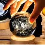 Lámpara decorativa cristal 3D sistema solar grabada, mano iluminando esfera, luz cálida ambiental.