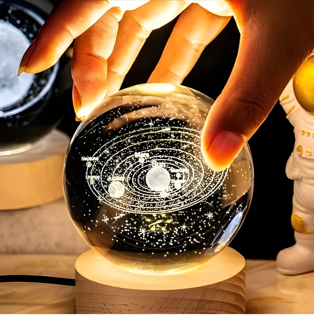 Lámpara decorativa cristal 3D sistema solar grabada, mano iluminando esfera, luz cálida ambiental.