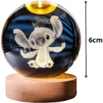 Lámpara de mesa LED bola cristal con figura 3D de Stitch grabada, base de madera clara, altura total 6cm.