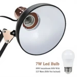 Lámpara Pixar articulada negra con detalles en cobre, base ajustable, pantalla amplia y foco LED de 7W sugerido en fondo blanco.