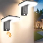 Lámparas solares LED exteriores grises con sensor de movimiento, iluminan un camino y casa.