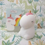 Lámpara nocturna unicornio blanco táctil LED, con caja y fondo temático de jungla.