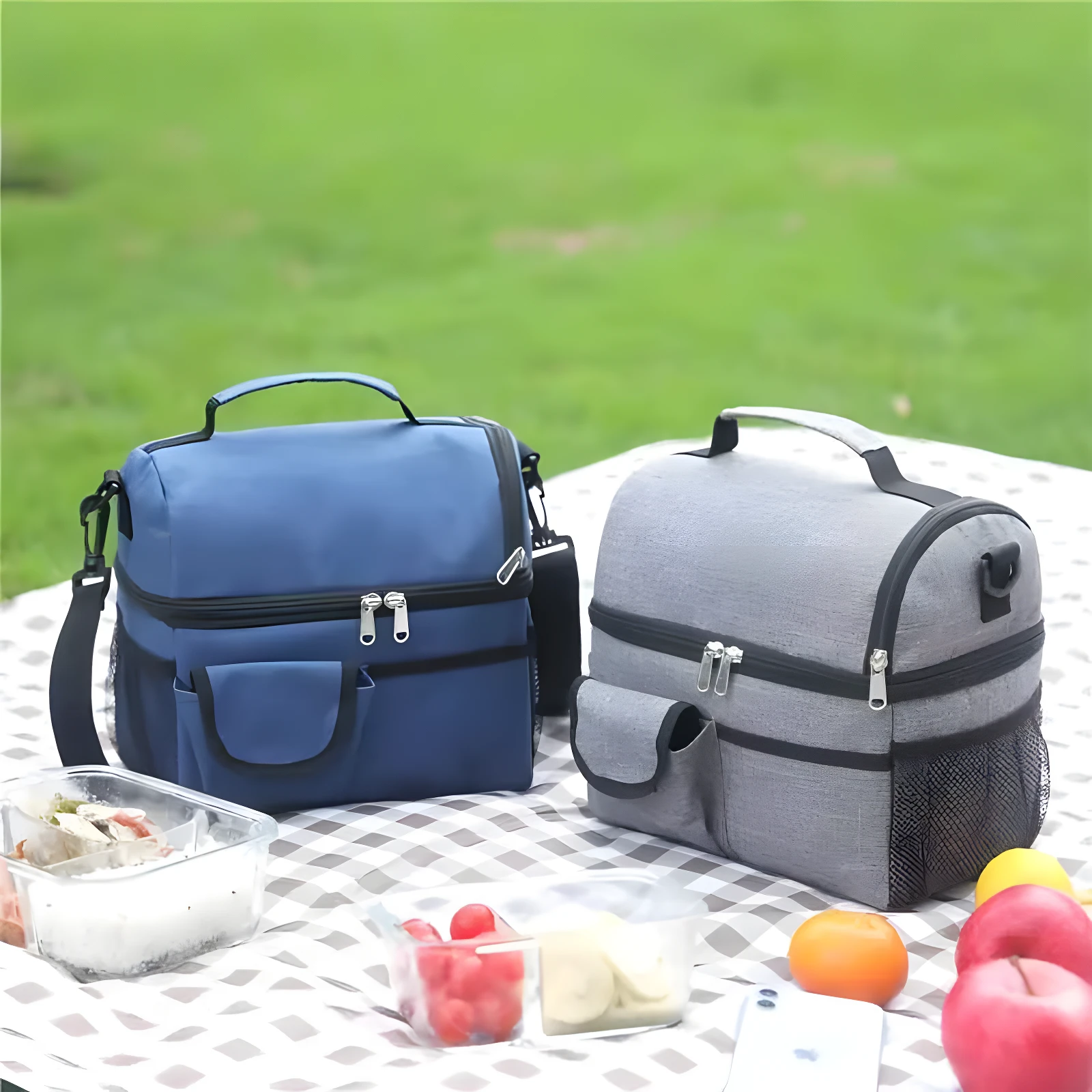 Loncheras térmicas azul y gris con doble compartimiento, ideales para picnic, con contenedores de comida y frutas.
