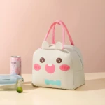 Lonchera térmica infantil con cara de conejo, asas rosas, junto a lata y recipiente. Ideal para mantener alimentos frescos.