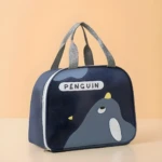 Lonchera térmica azul marino con diseño de pingüino, asas grises, cremallera blanca. Ideal para mantener alimentos frescos.