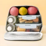 Lonchera térmica MLJ-1052 abierta, con compartimentos apilables, botellas, frutas y comida.