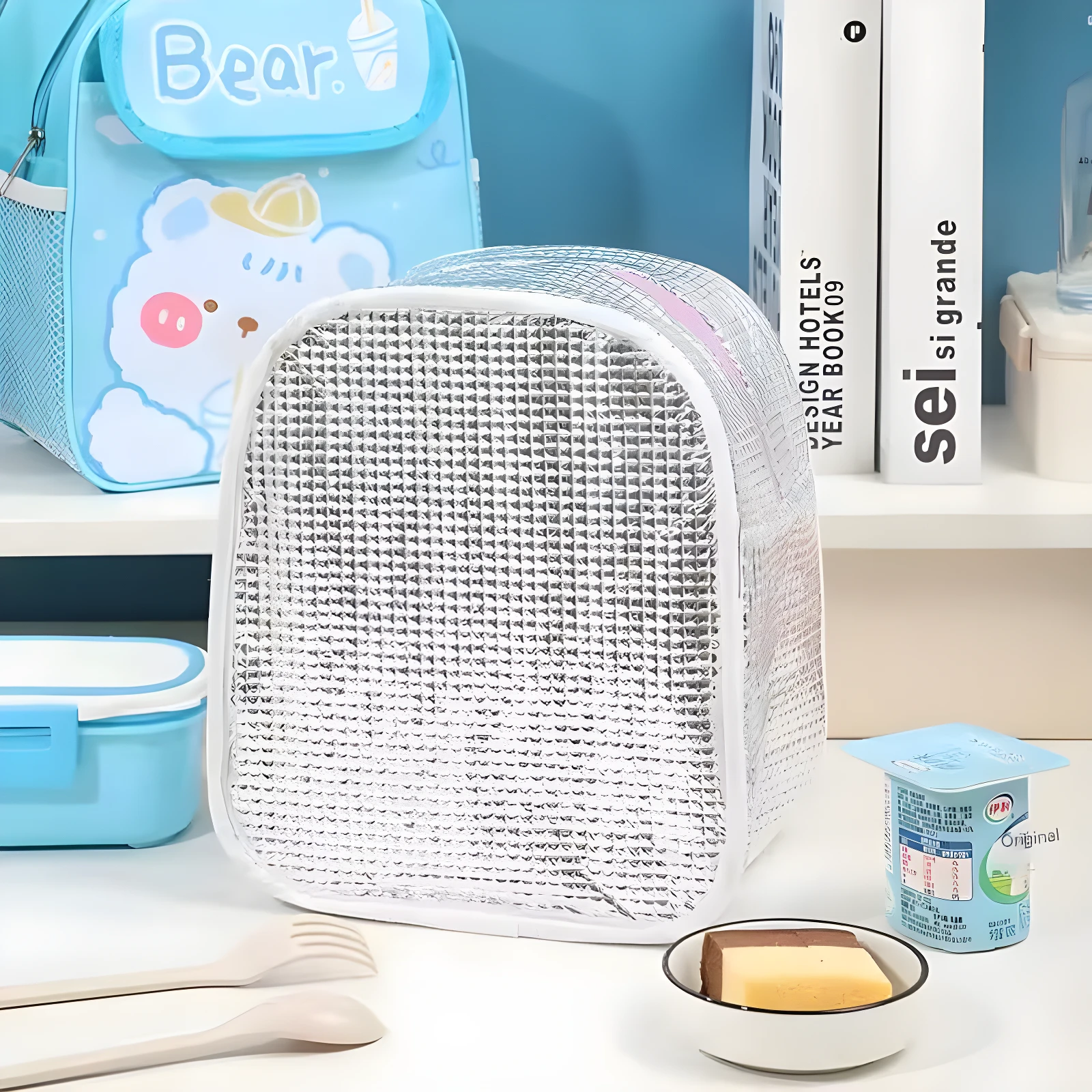 Lonchera térmica plateada MLJ-1053 con oso azul, cubiertos y postre.