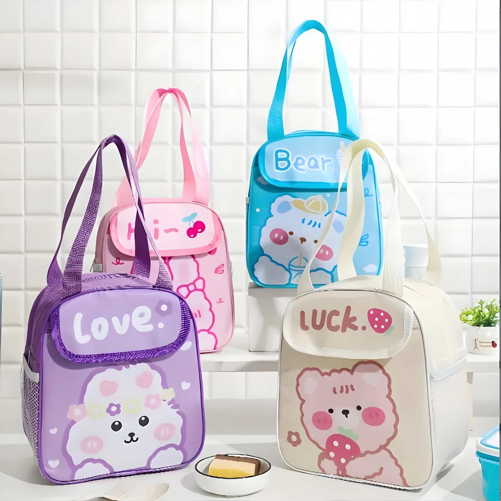 Cuatro loncheras térmicas para niños con diseños de osos y flores, en colores morado, rosa, azul y crema.