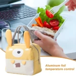 Lonchera térmica amarilla con orejas de conejo, ideal para mantener alimentos calientes o fríos en la oficina.