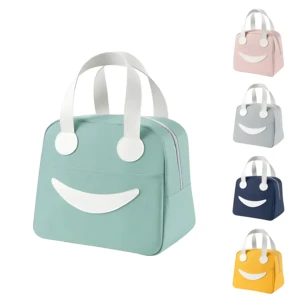 Lonchera térmica portátil con diseño de cara sonriente, disponible en verde menta, rosado, gris, azul oscuro y amarillo, con asas blancas y cierre lateral.