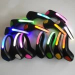 Diez luces LED deportivas negras para calzado con bandas luminosas de colores vibrantes: azul, verde, rosa, amarillo y naranja.