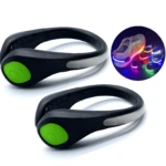 Dos luces LED deportivas negras con botón verde para taloneras, y círculo insertado mostrando uso multicolor en calzado.