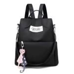 Mochila negra antirrobo de mujer en material liso, con etiqueta "QIYIBEI" y llavero de dos gatos durmiendo con corazones.