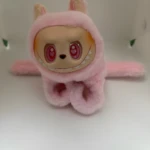 Manilla Labubu peluche rosa suave con orejas, cara de vinilo sonriente con ojos rojos de corazón, y detalle de colmillos blancos.