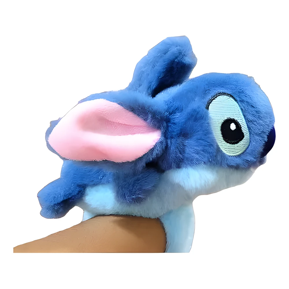 Manilla peluche Stitch azul suave, orejas rosadas grandes, vista lateral sobre muñeca en primer plano.