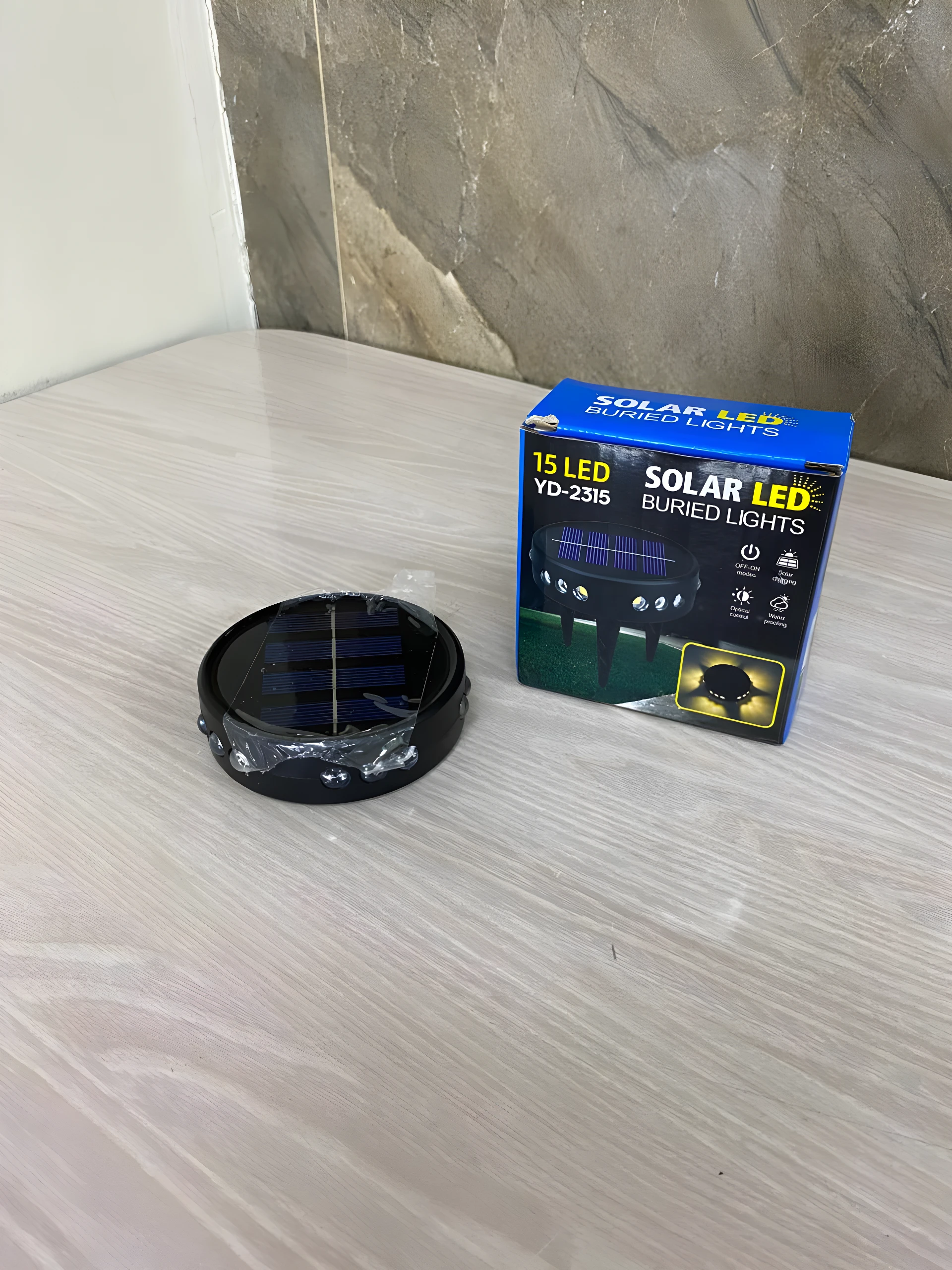 Lámpara solar enterrada para jardín, 15 LED, modelo YD-2315, color negro, con panel solar visible y luces LED en su base.