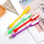 Mini lámparas LED USB flexibles: amarillas, verdes, rojas y púrpuras iluminando sobre un libro.